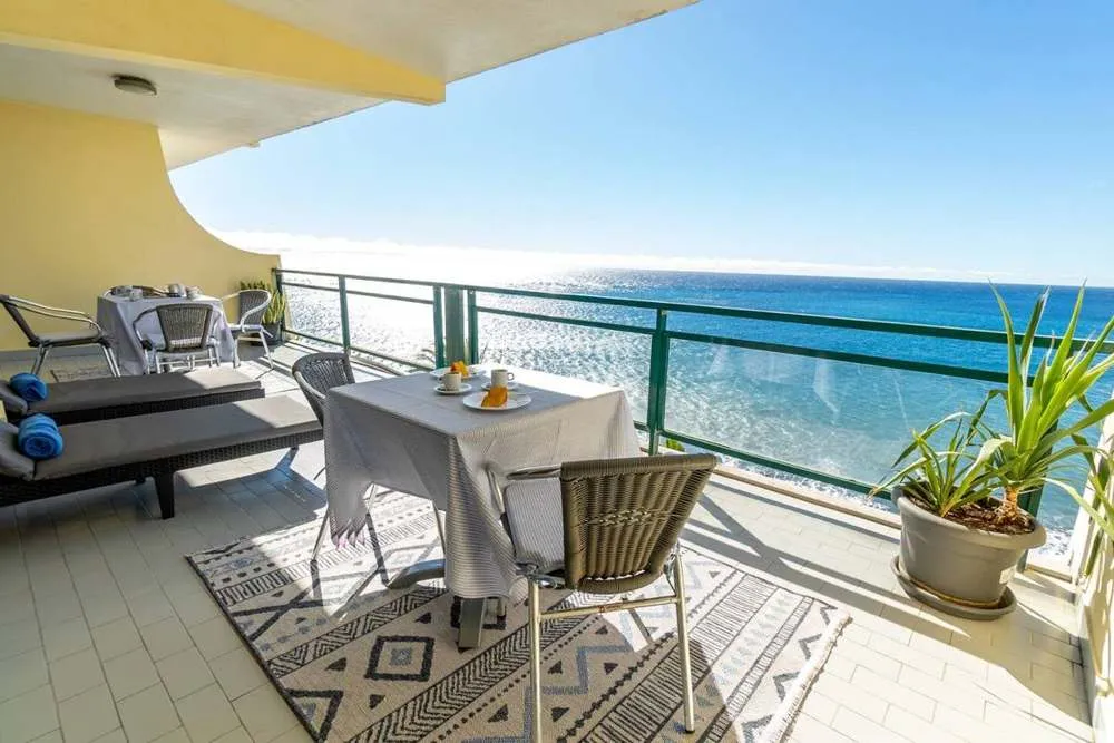 Large balcony with a beautiful ocean and mountain view.