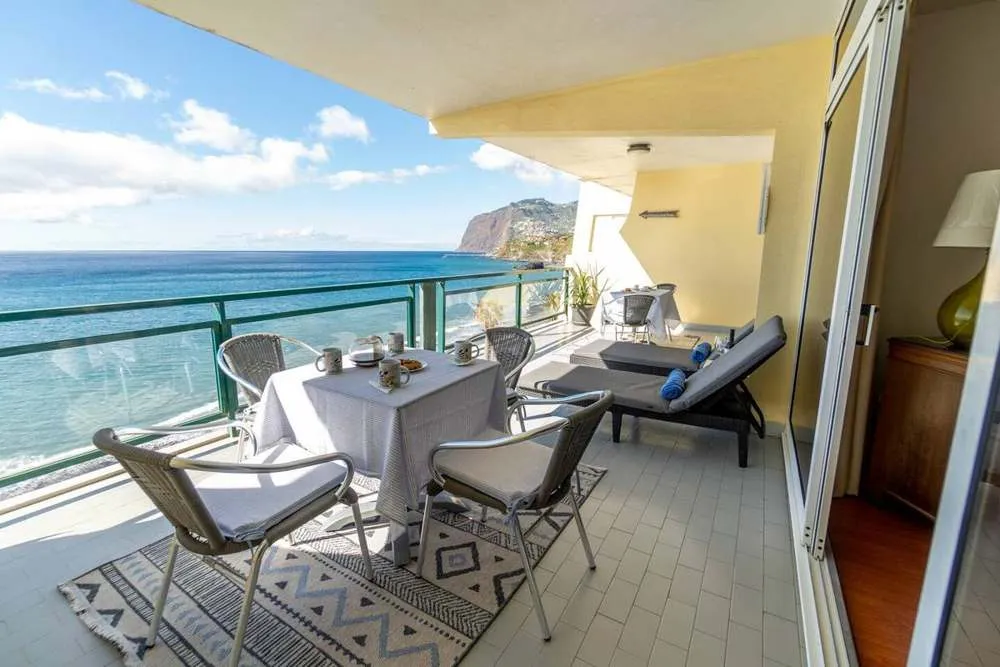 Large balcony with a beautiful ocean and mountain view.