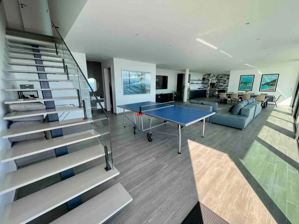 Large entertainment area downstairs fully dedicated to lounging. Includes a large 85" TV, table tennis table, table football table, barbecue, dining area and leads to the infinity pool and outdoor area.