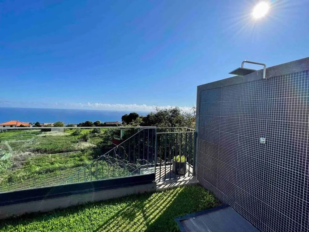 Outdoor shower surrounded by mountain and sea views.