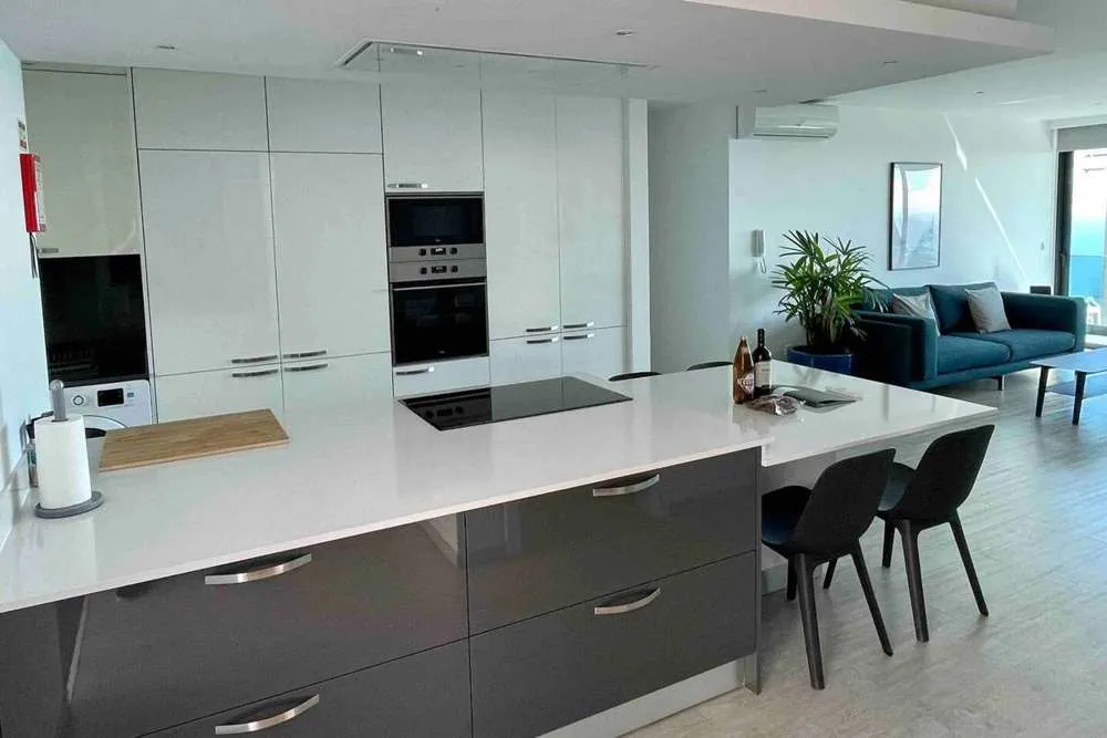 Upstairs kitchen leading to the lounge, dedicated workspace and balcony.