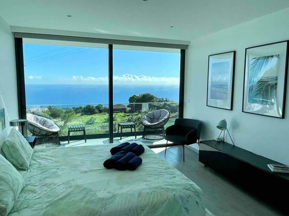 The master bedroom suite includes a private bathroom, walk in wardrobe and leads on to the upstairs balcony with sea and mountain views.